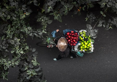 Top view of the fruit seller walking with bicycle along the street. Vietnamの写真素材