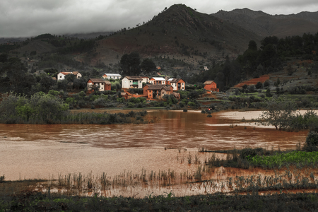 Small village on the coast of river with brown water. Madagascarの写真素材