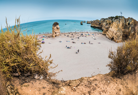 Sandy beach surrounded by limestone mountains. Portugalの写真素材
