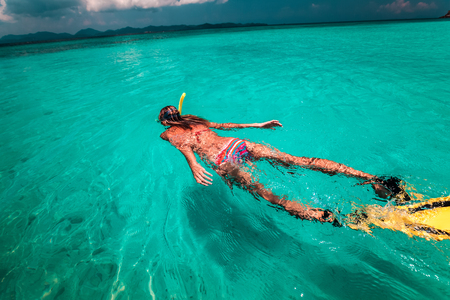 The young lady is swimming with snorkel and finsの写真素材