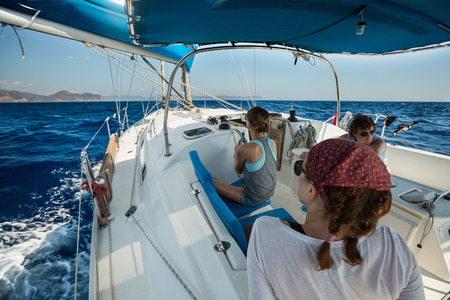 Group of young friends sailing in a blue seaの写真素材