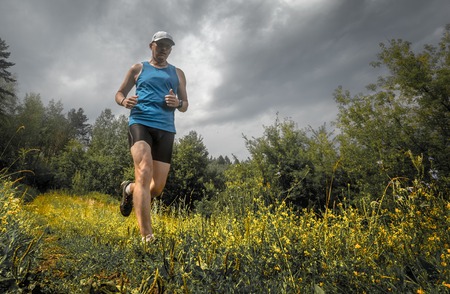 Trail running athlete moving through the meadow
