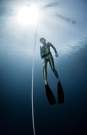 Underwater shot of the ascending free diver. Free immersion disciplineの写真素材