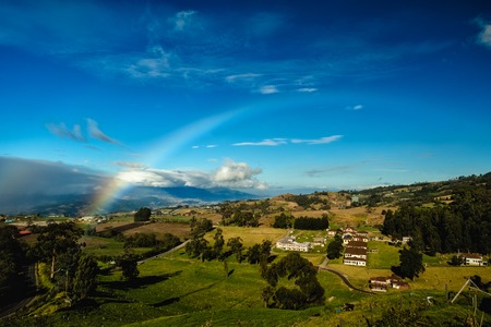 Green meadows and rainbow. View from slope of volcano of Irazu to the valley. Costa Ricaの写真素材