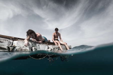 Two men floating in the tropical sea and waiting for resqueの写真素材
