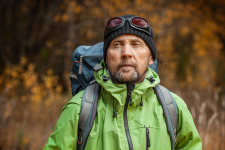 Mature backpacker in an autumn forestの写真素材