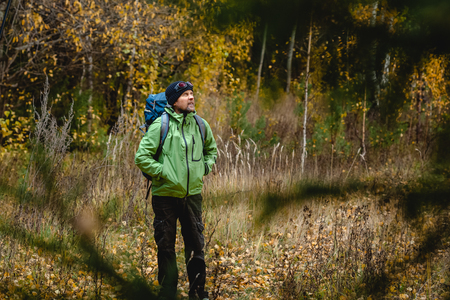 Mature backpacker in an autumn forestの写真素材