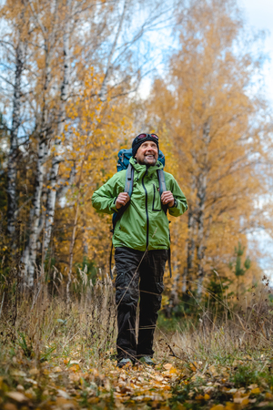 Mature backpacker in an autumn forestの写真素材