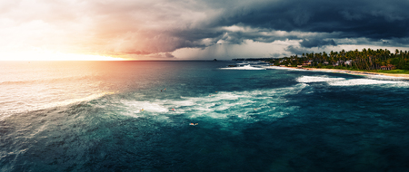 Panorama of the surf spot named Coconut with surfers on the line up. Stormy weather surfing conditionsの写真素材