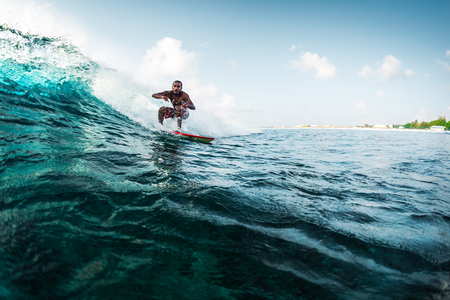 Young surfer rides the wave. Extreme sport and active lifestyle conceptの写真素材