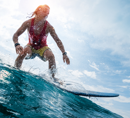 Young surfer rides the ocean waveの写真素材