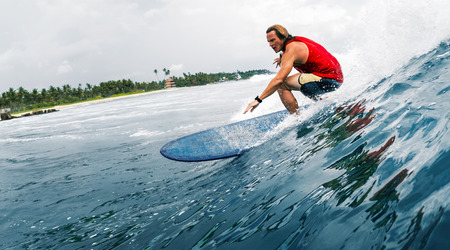 Young surfer rides the ocean waveの写真素材