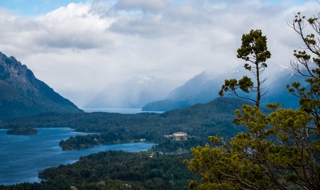 Lakes and mountains in the Lake district near the town of Bariloche, Argentina. Focus on the tree on foregroundの写真素材