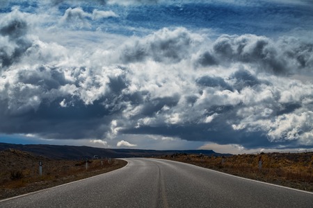 Asphalt road and sky with cloudsの写真素材