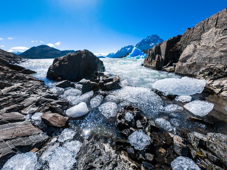 Ice pieces floating near the rocky coast. Glacier of Grey in Torres del Paine National Park, Chileの写真素材