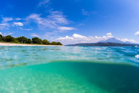 Tropical beach on Bali. Split shot with underwater view of the tropical beach located on the island of Bali, Indonesiaの写真素材
