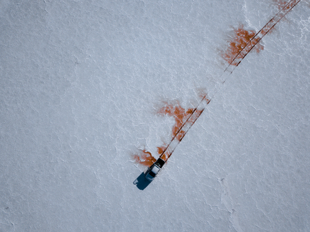 Aerial shot of the car got stuck at the muddy place in the middle of Salar de Uyuni, Boliviaの写真素材