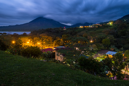 Village with highlighted buildings and tropical gardens near the volcano of Arenal, Costa Ricaの写真素材