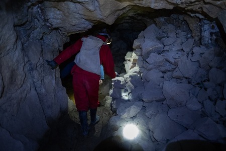Tourist walks inside the cooperative mine in the city of Potosi, Bolivia. Image has high level of noiseの写真素材