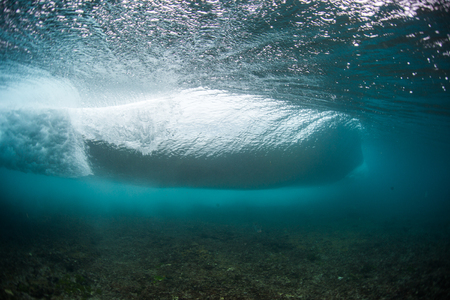 Underwater view of an ocean wave breaking over coral reefの写真素材