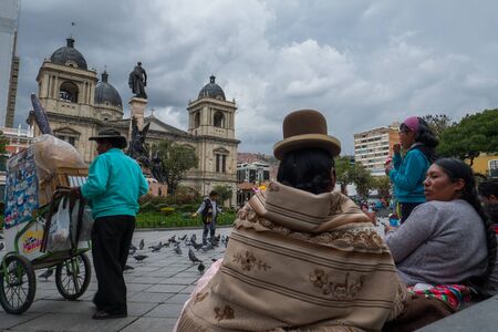LA PAZ, BOLIVIA - 24 MARCH, 2018: Two indigenous bolivian women sit on the stairs at Plaza Murilloのeditorial素材