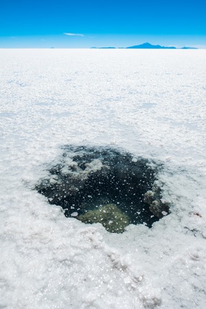 Hole with salty water in the middle of the Salar de Uyuni, Boliviaの写真素材