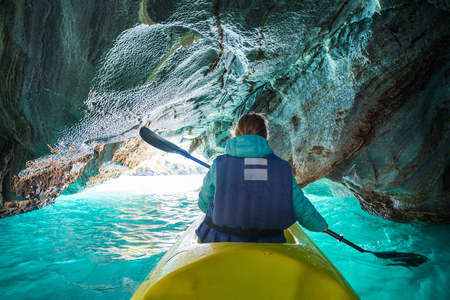 Woman paddles kayak and explores the Marble Caves on the lake of General Carrera, Chileの写真素材