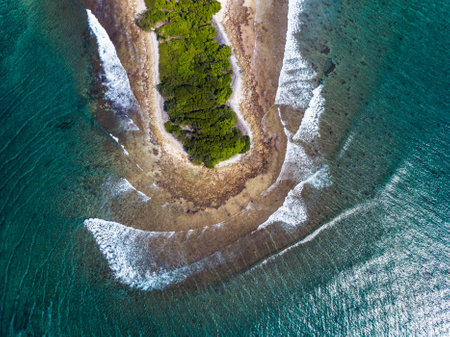 Aerial view of part of the island of Thanburudhoo with waves breaking over the reef, Maldivesの写真素材