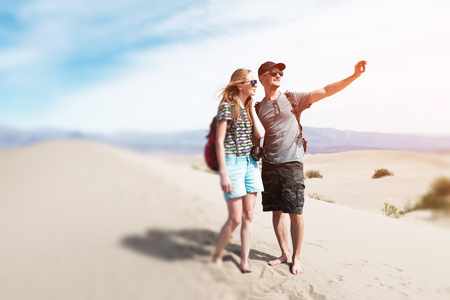 Couple of hikers takes selfie picture being on the sandy desert. The Death Valley, USA. Tilt shift effect appliedの写真素材