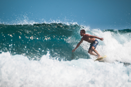 Amateur surfer rides the ocean waveの写真素材