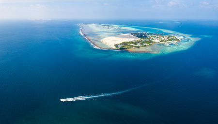 Aerial view of the boat moving in a tropical sea near the islandの写真素材