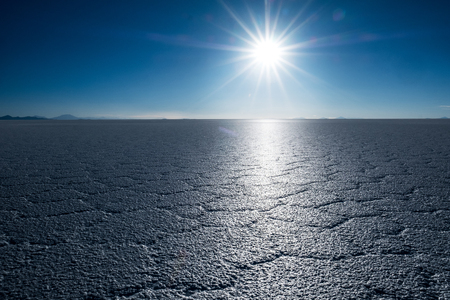 Salt surface of the Uyuni salt flat with cell patterns during sunset, Boliviaの写真素材