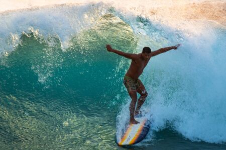 OAHU / USA - 17 NOVEMBER 2018: Polinesian surfer rides big ocean wave