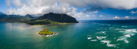 Aerial panorama of the island Mokolii (Chinamanâs Hat) surrounded by torquise ocean waves and mountains of the East Coast of Oahu, Hawaii.の写真素材