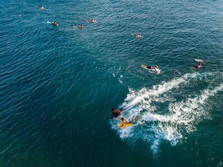 OAHU / USA - 17 NOVEMBER 2018: Two boys ride ocean wave on their bodyboards while other surfers paddle to line up on the background. Oahu, Hawaiiのeditorial素材