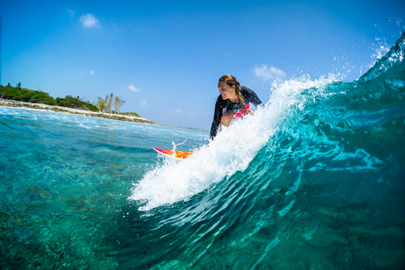 Happy lady surfer rides the tropical wave at sunny dayの写真素材
