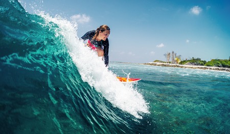 Happy lady surfer rides the tropical wave at sunny dayの写真素材