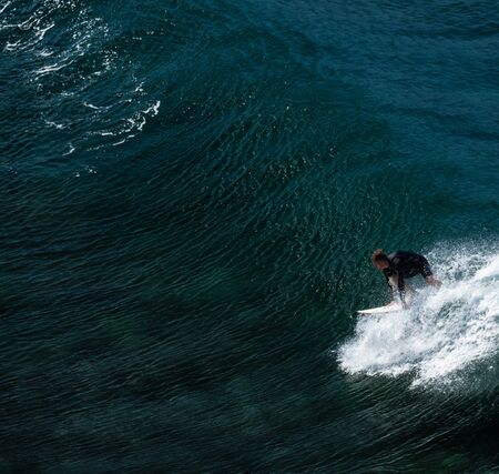 MAUI / USA - 14 DECEMBER 2018: Surfer takes off on the perfectly shaped ocean waveのeditorial素材