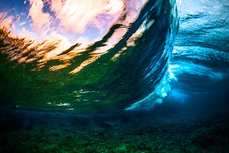 Underwater view of the crystal clear ocean wave barreling over the coral reefの写真素材