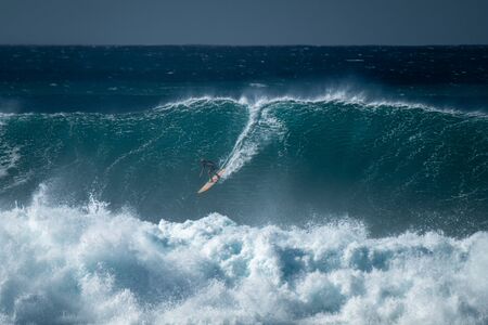 OAHU / USA - DECEMBER 05, 2019: Surfer rides giant wave at the famous Waimea Bay surf spot located on the North Shore of Oahu in Hawaiiのeditorial素材