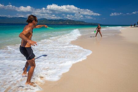 Couple play badminton on the tropical beachの写真素材