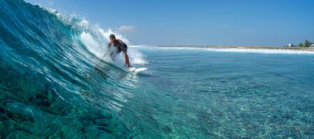 Surfer rides ocean wave in tropicsの写真素材