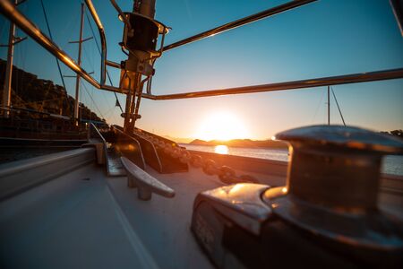 Bow of the sailing vessel with anchor chain at sunriseの写真素材