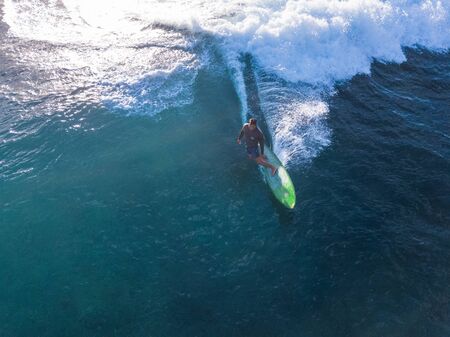 OAHU, HI / USA - NOVEMBER 15, 2018: Aerial view of the adult man surfer riding the ocean wave on the longboardのeditorial素材