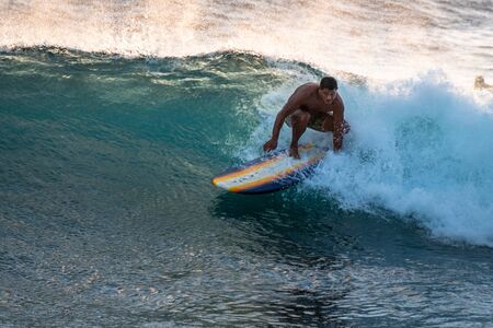 OAHU, HI / USA - NOVEMBER 17, 2018: Adult surfer rides the ocean wave on a longboard