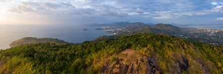 Aerial panorama of the island of Phuket during sunset. Area of the Black Rock viewpoint (the viewpoint itself is an area with dry yellow grass on the foreground). Thailandの写真素材