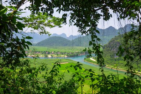 Lush vegetation and blue river flowing in the valley with mountains. Vietnamの写真素材