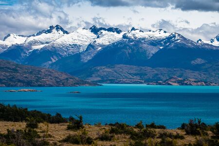 Snow capped mountains and blue lake of General Carrera in Chilean Patagoniaの写真素材