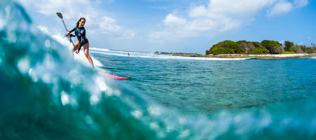 HURAA , MALDIVES MARCH 10, 2019: Young woman surfs the wave on the Sultans surf spot in Maldivesのeditorial素材
