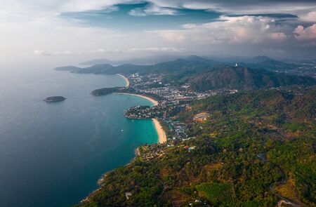 Aerial view of the coastline of Phuket island with tropical sandy beaches and mountains at sunset, Thailandの写真素材